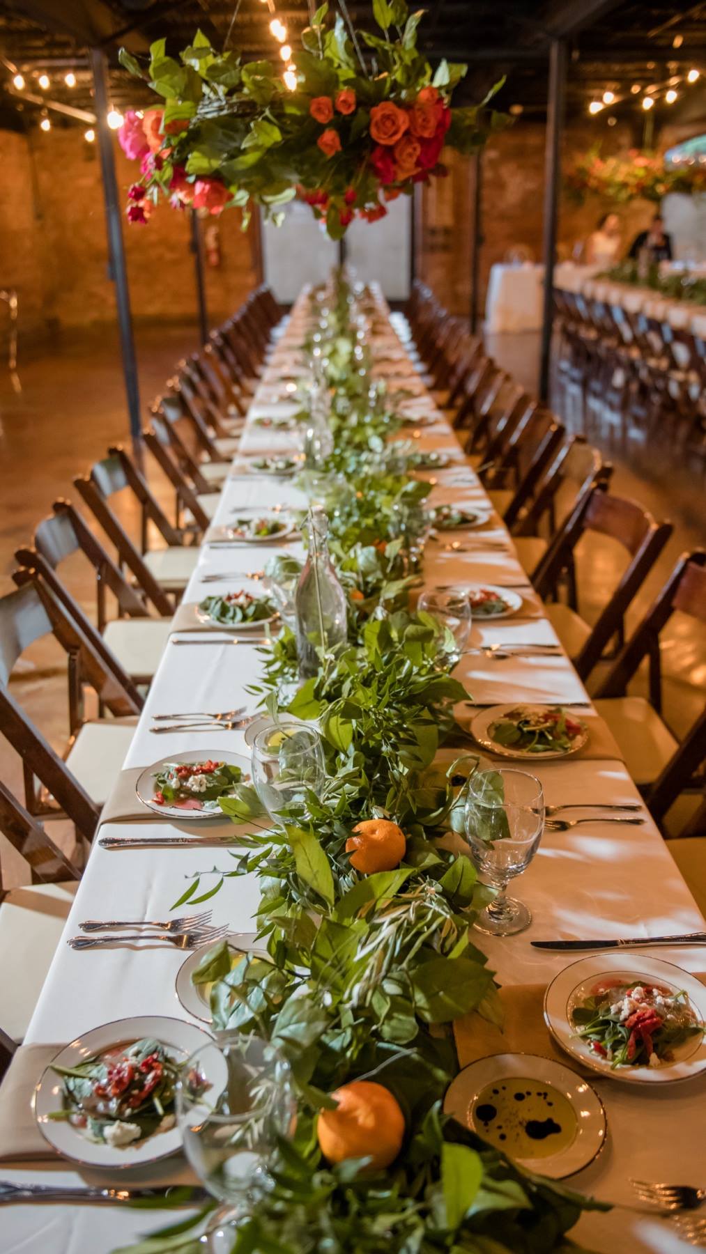 long wedding reception table with greenery table runner