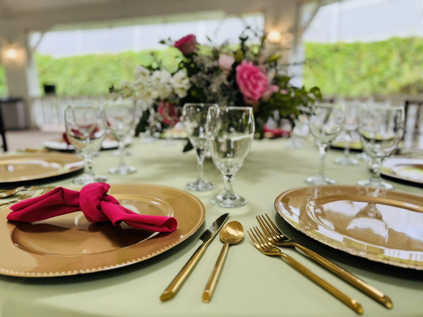 wedding reception table with gold accents and pink floral centerpieces